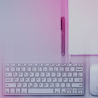 a keyboard and a pen on a desk